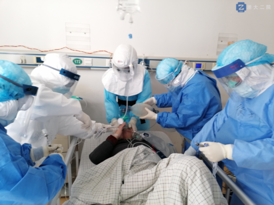 李立斌主任（中）戴著正壓頭套，為新冠肺炎危重癥病人